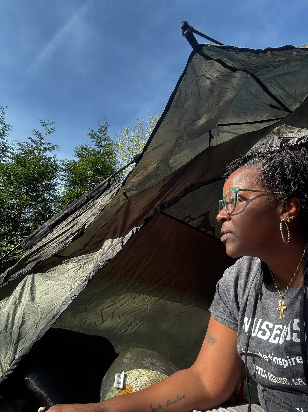 A retreat participant taking a quiet moment beside a tent